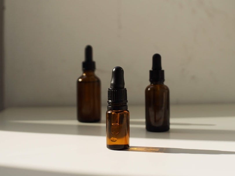 three bottles of essential oils sitting on a shelf