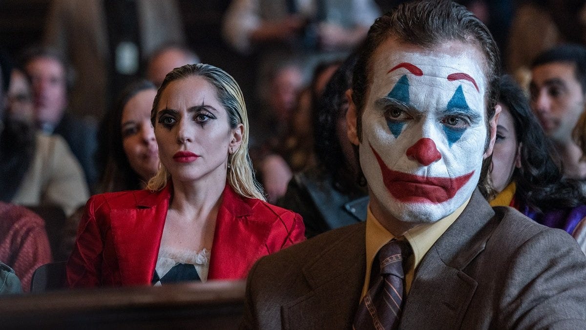 Harley (Lady Gaga) and Joker (Joaquin Phoenix) wear clown makeup in court in Joker: Folie a Deux.