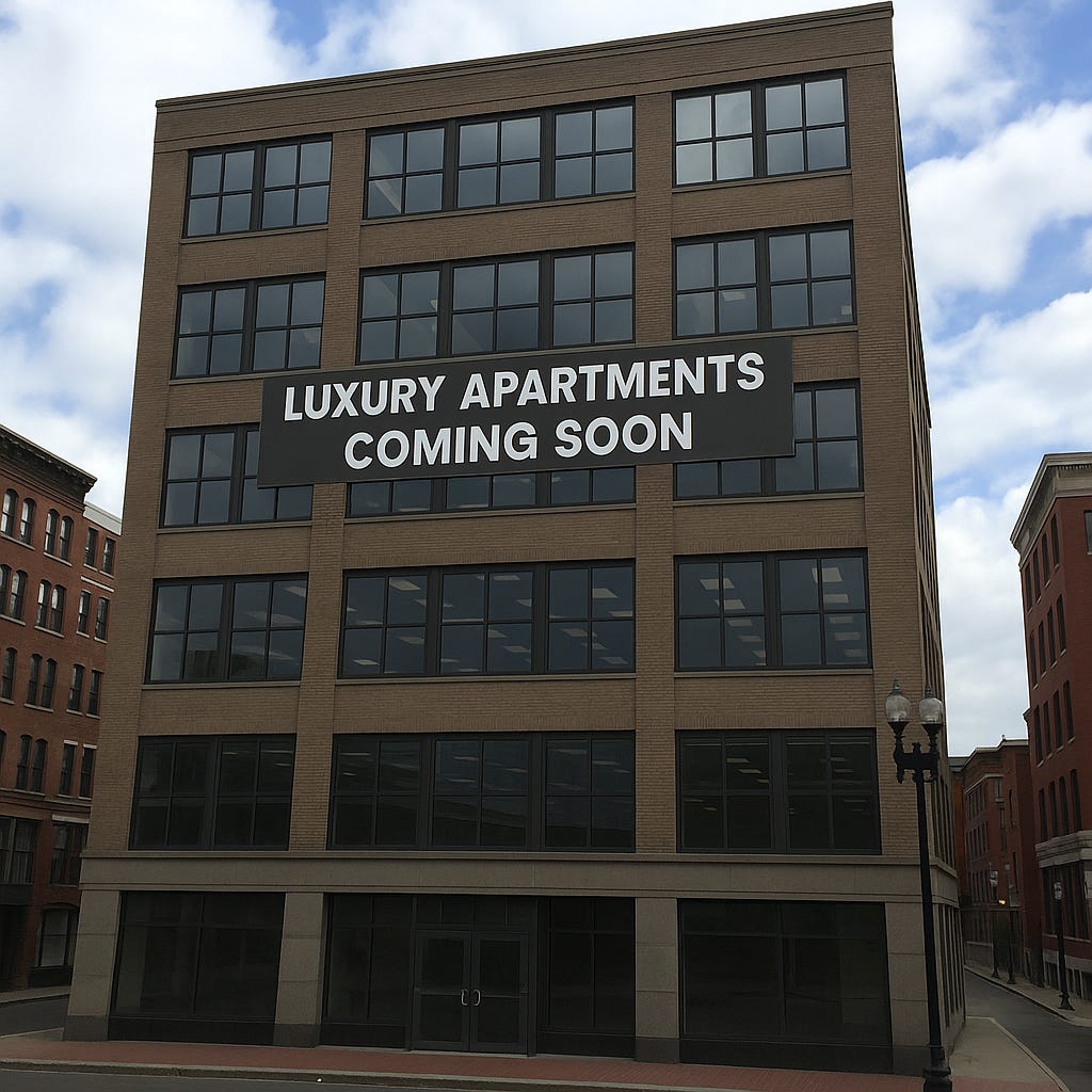 Six-story office building in Boston with a sign reading, "LUXURY APARTMENTS COMING SOON."