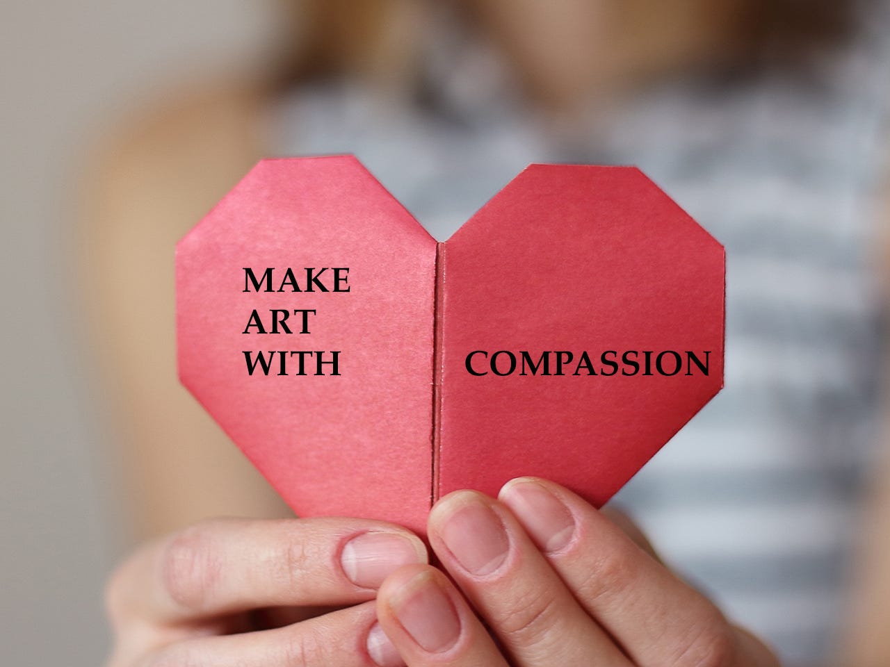 hands holding a heart with the words "Make Art with Compassion" on the heart.