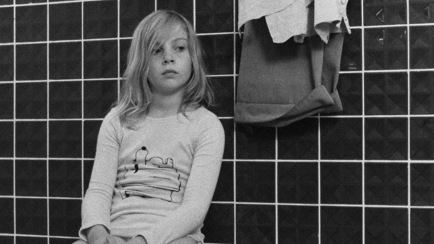 Alice in the Cities | Features a young girl sitting against a bathroom wall.