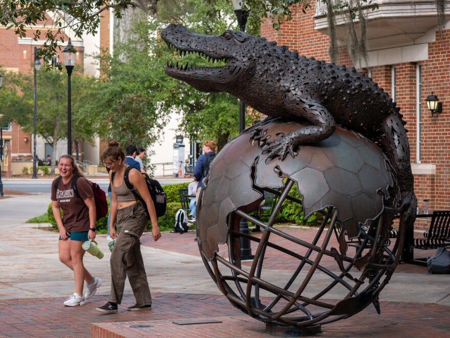 Students walk by On Top Of The World, a statue outside of the University of Florida’s Warrington College of Business Administration’s undergraduate building in Gainesville. (Ethan Goddard/ Fresh Take Florida)