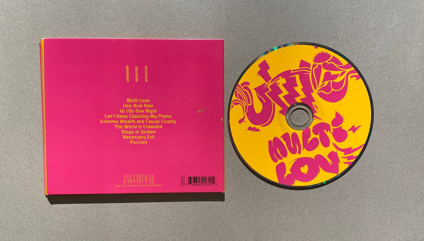 the pink back cover for Multi-Love featuring the tracklist, plus the yellow and pink CD.