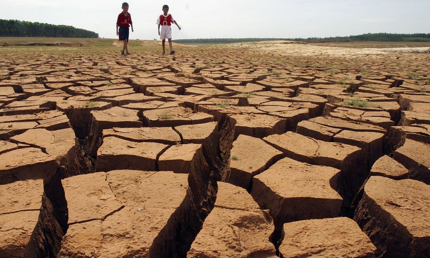 Young boys play at the bottom of a cracked, dried reservoir in western Guangdong Province, southern China.