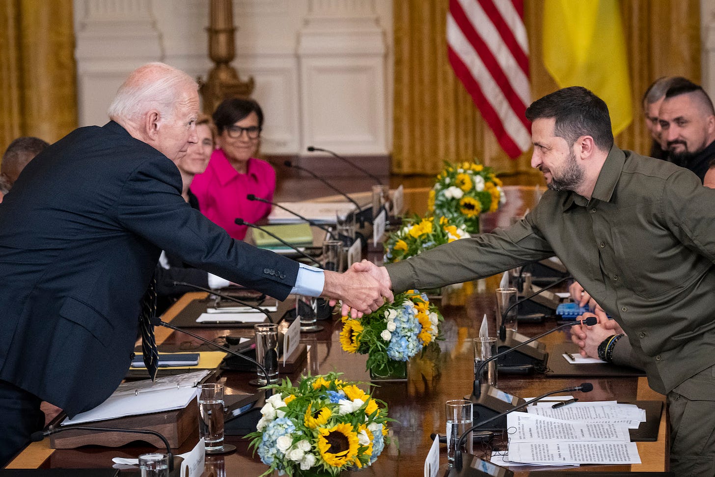 U.S. President Joe Biden shakes hands with Ukrainian President Volodymyr Zelensky.
