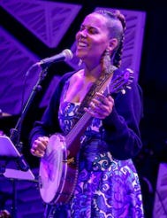 Detail of a news photo of Rhiannon Giddens playing a banjo onstage
