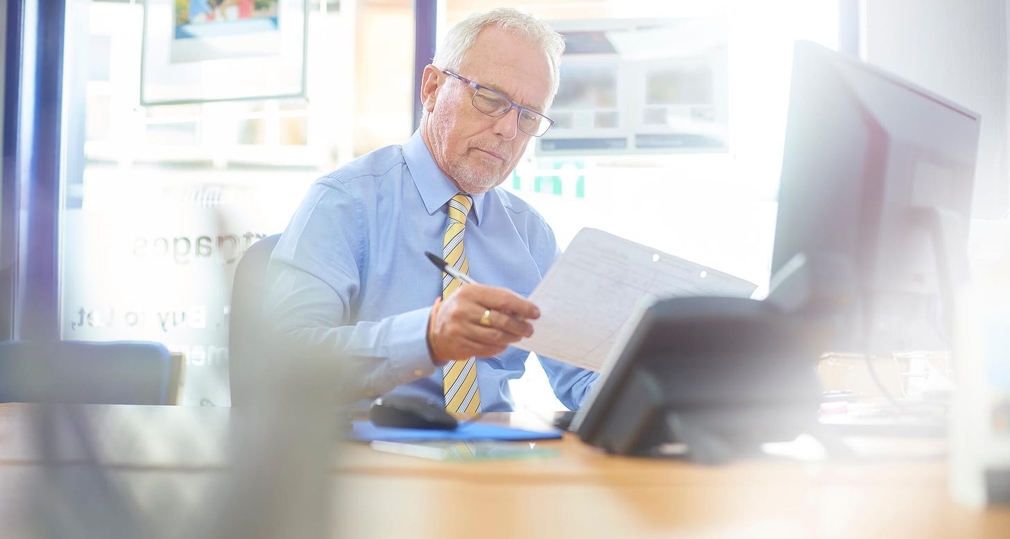 A business owners sits at his desk checking his company's profit and loss figures