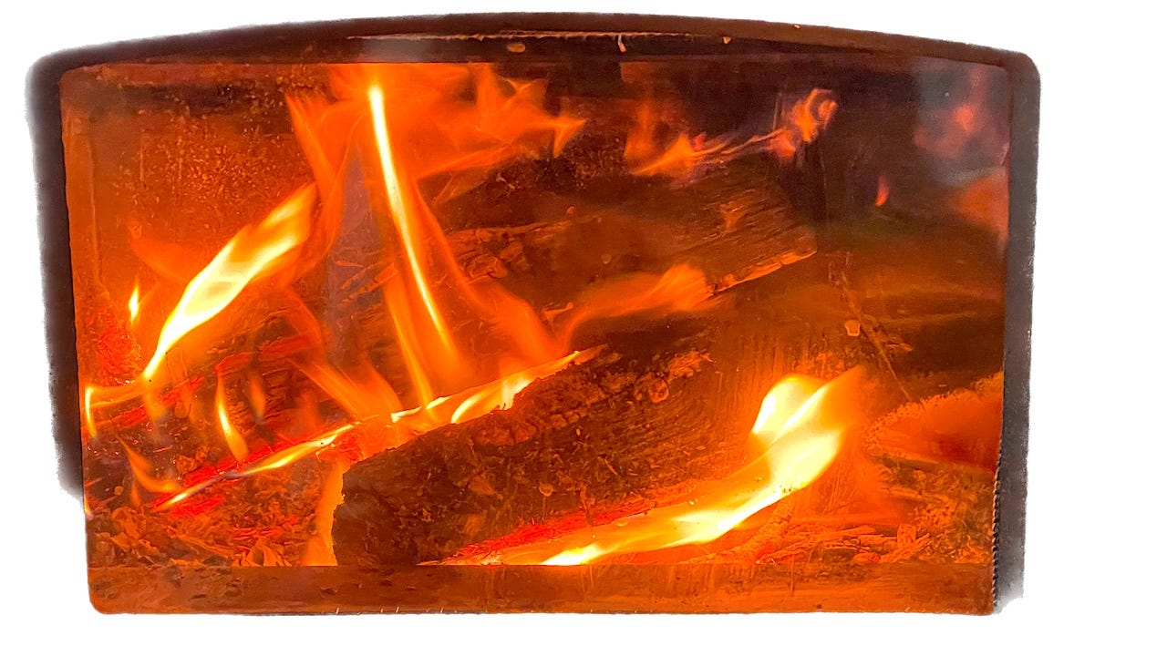 two logs burning brightly in a wood stove with visible flames and a bright orange glow