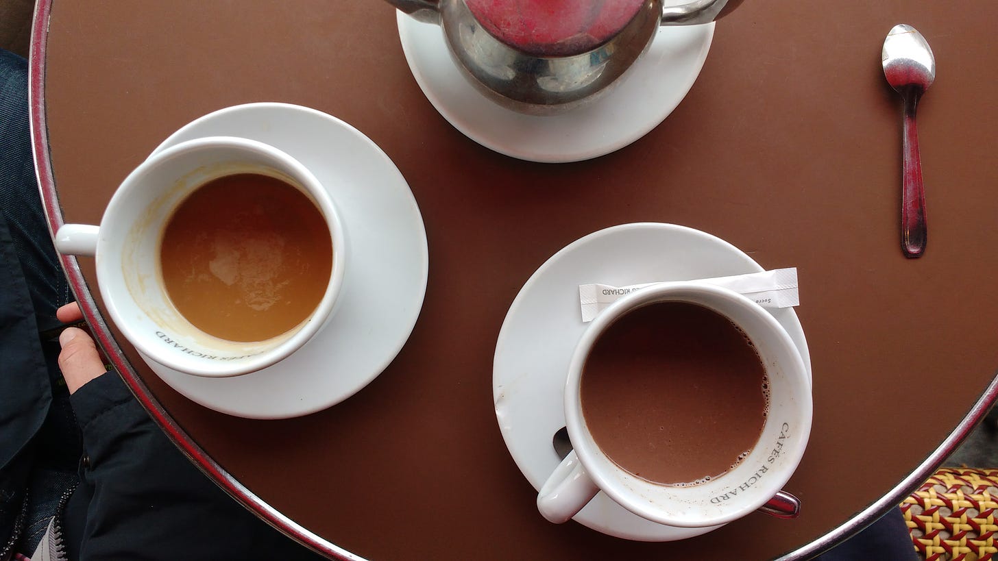 Cafe table with teapot and coffee cups in Paris, France