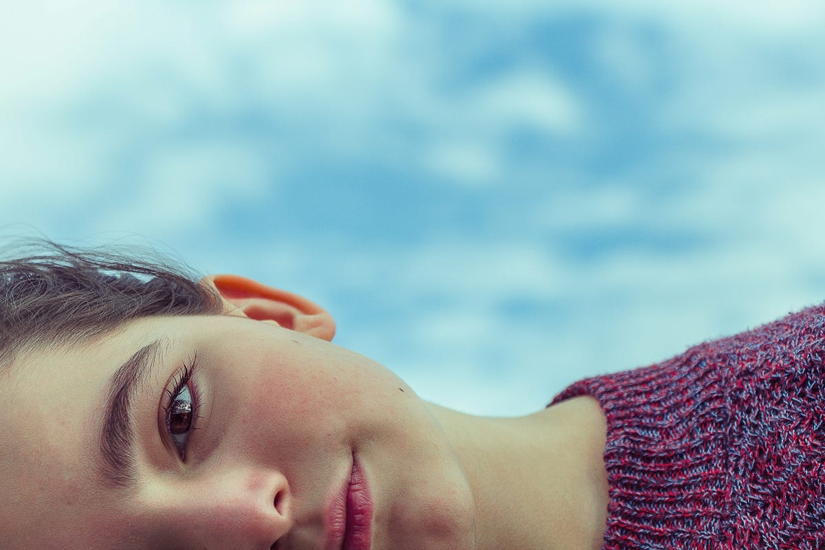 Person lying down and looking at camera Person lying down and looking at camera