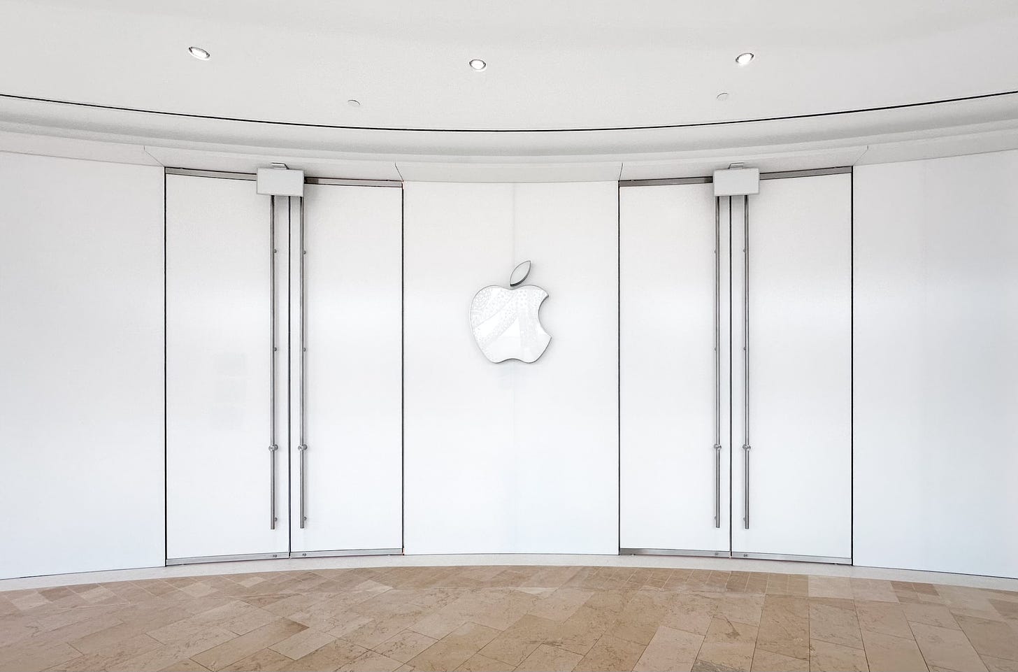 The covered facade of Apple Square One. Two sets of double doors are set in curved glass.