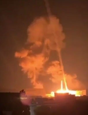 Fire whirl over buildings at night.