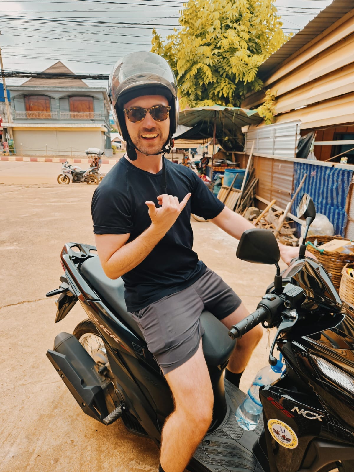 jack mann sits on scooter in laos ahead of a trip to the bolaven plateau and the thakek loop