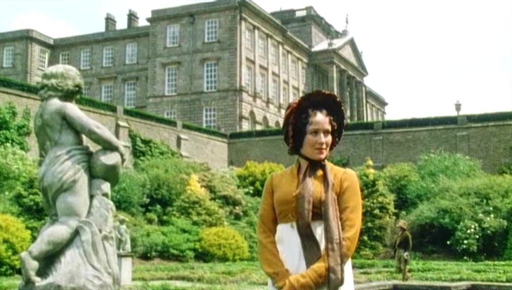 Elizabeth Bennet standing next to a statue in the gardens at Pemberley. 
