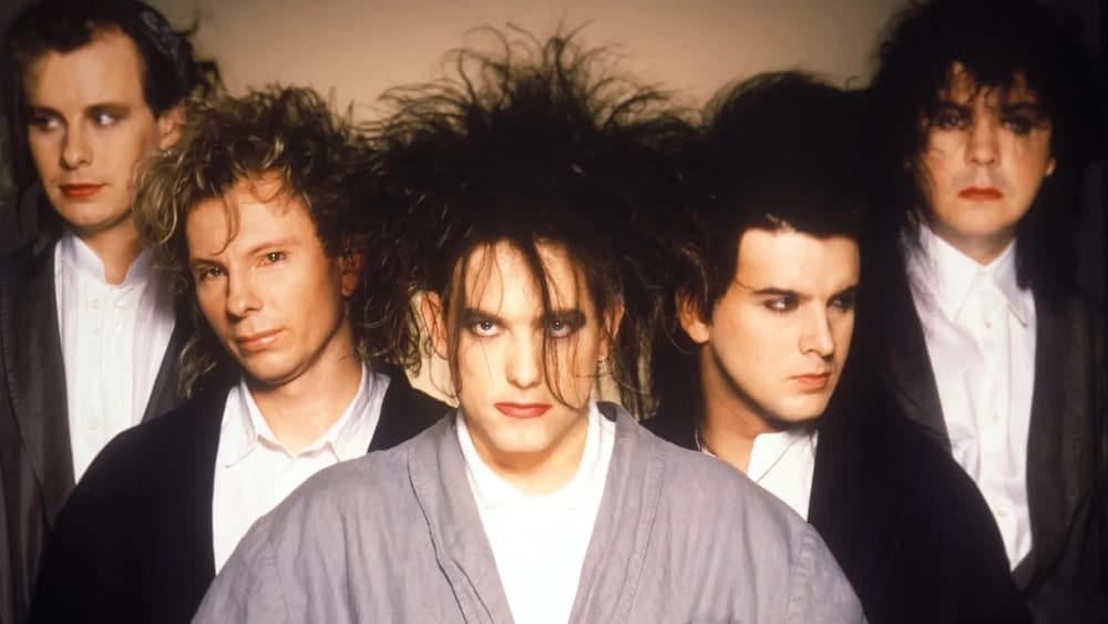 The members of The Cure arrayed behind Robert Smith