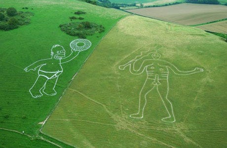 A giant homer simpson faces off with the chalk giant Cerne in Dorset