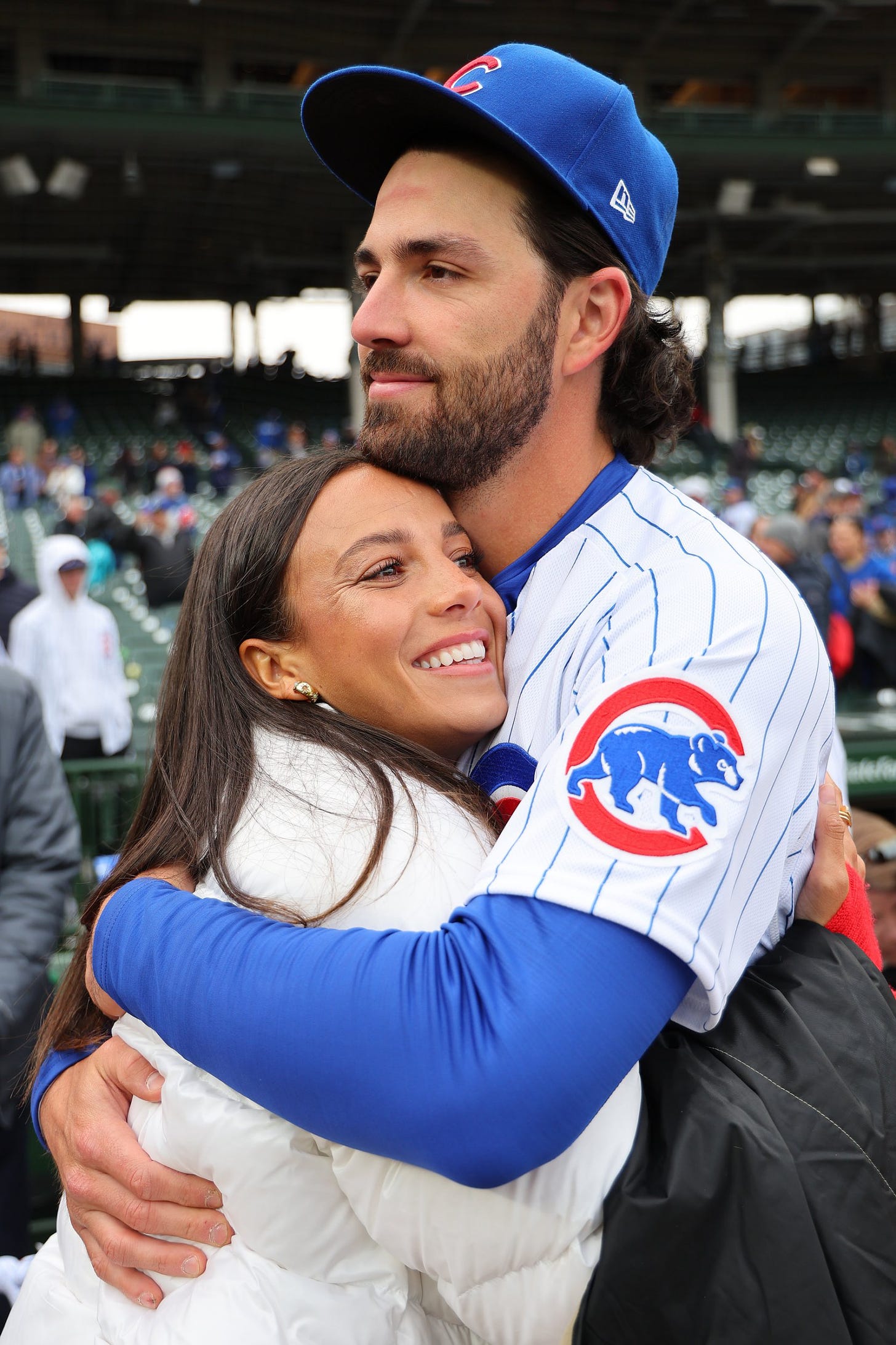 Dansby Swanson of the Chicago Cubs embraces his wife, Mallory Pugh Swanson, after winning the game against the Milwaukee Brewers at Wrigley Field in Chicago, Illinois, on March 30, 2023