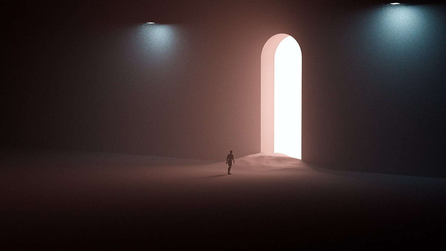Person Standing on the Sand Facing a Door with Light