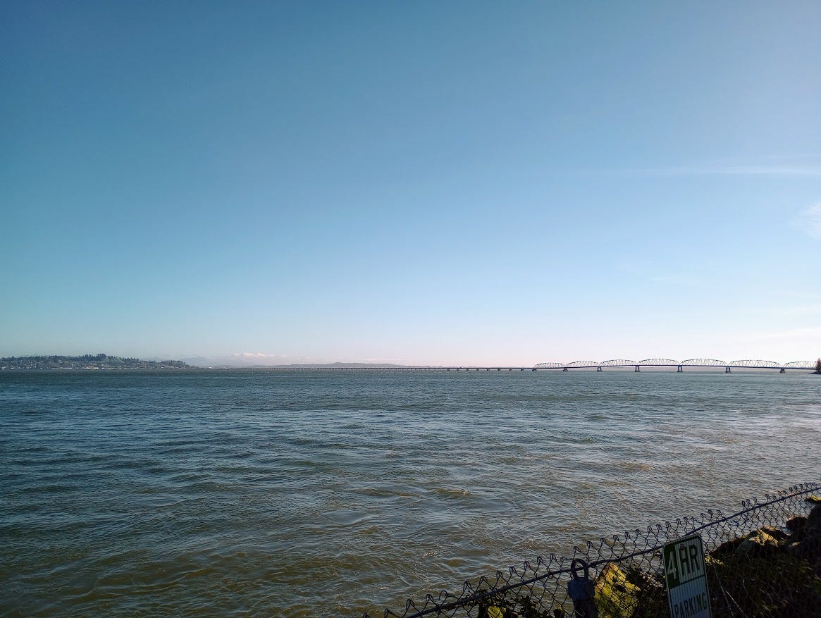 View of wide Columbia River estuary from Washington state side, including long bridge