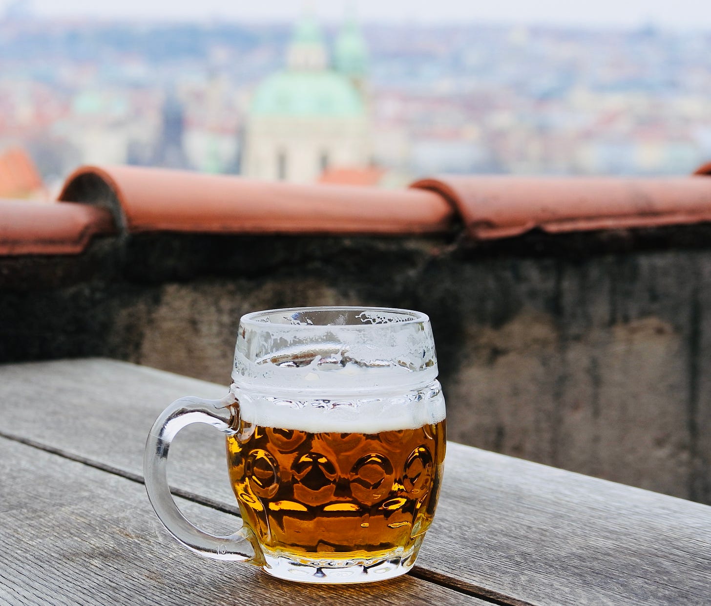 A glass of beer with the Prague skyline