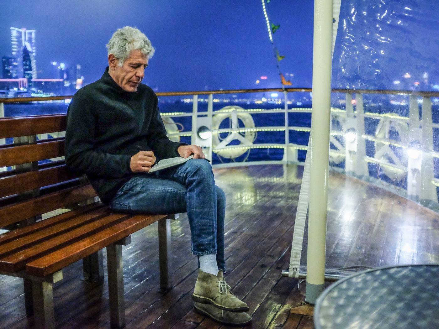 Anthony Bourdain writing on boat in Hong Kong episode of Parks Unknown