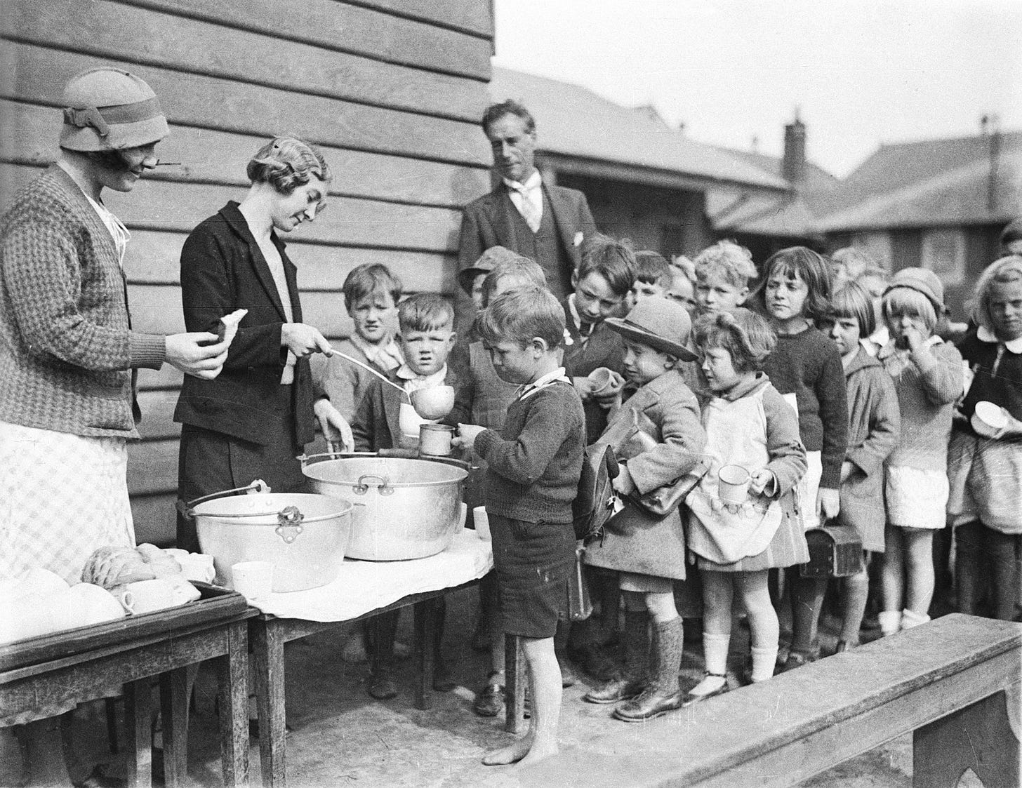 School children line up for free issue of soup and a slice of bread during the Depression, August, 1934