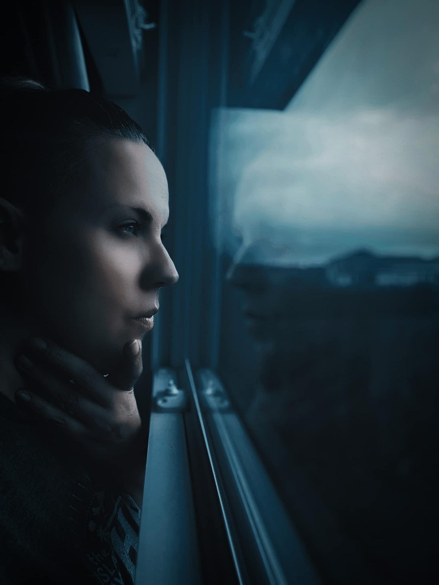 Tamara Driskell stares out window as her reflection mirrors her image