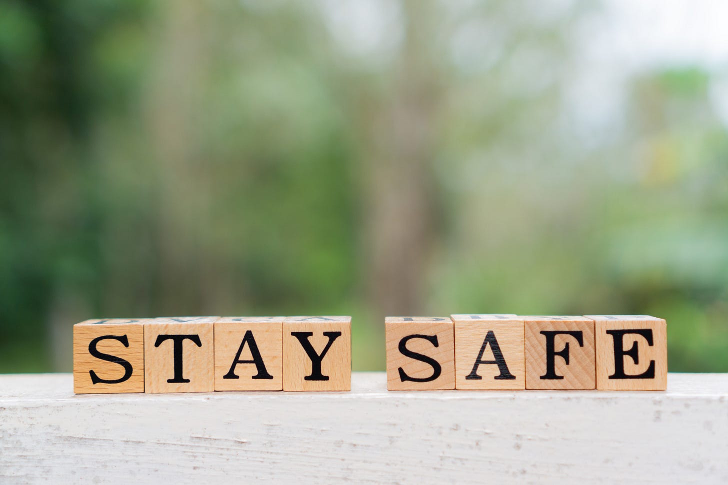 Close-up of wooden block letters spelling “Stay safe”