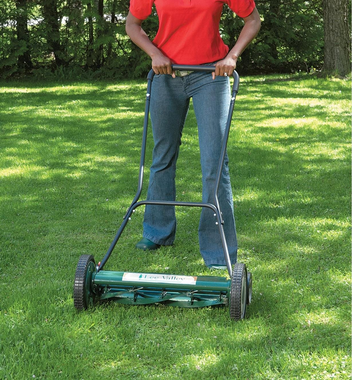 A woman pushes the Lee Valley 20"  Mower over grass