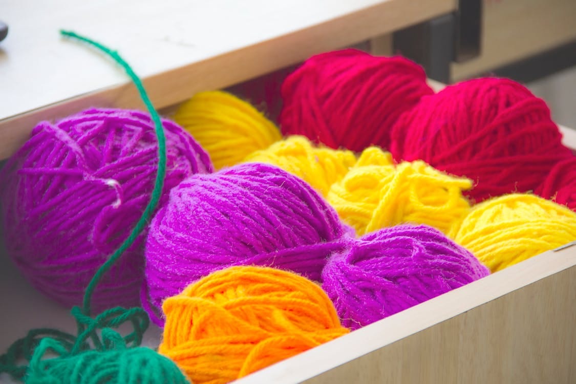 Free Vibrant and colorful yarn balls neatly organized in a drawer, perfect for knitting and textile projects. Stock Photo