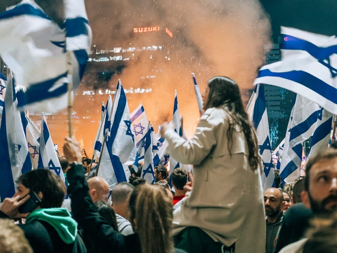 a large group of people holding flags in front of a crowd