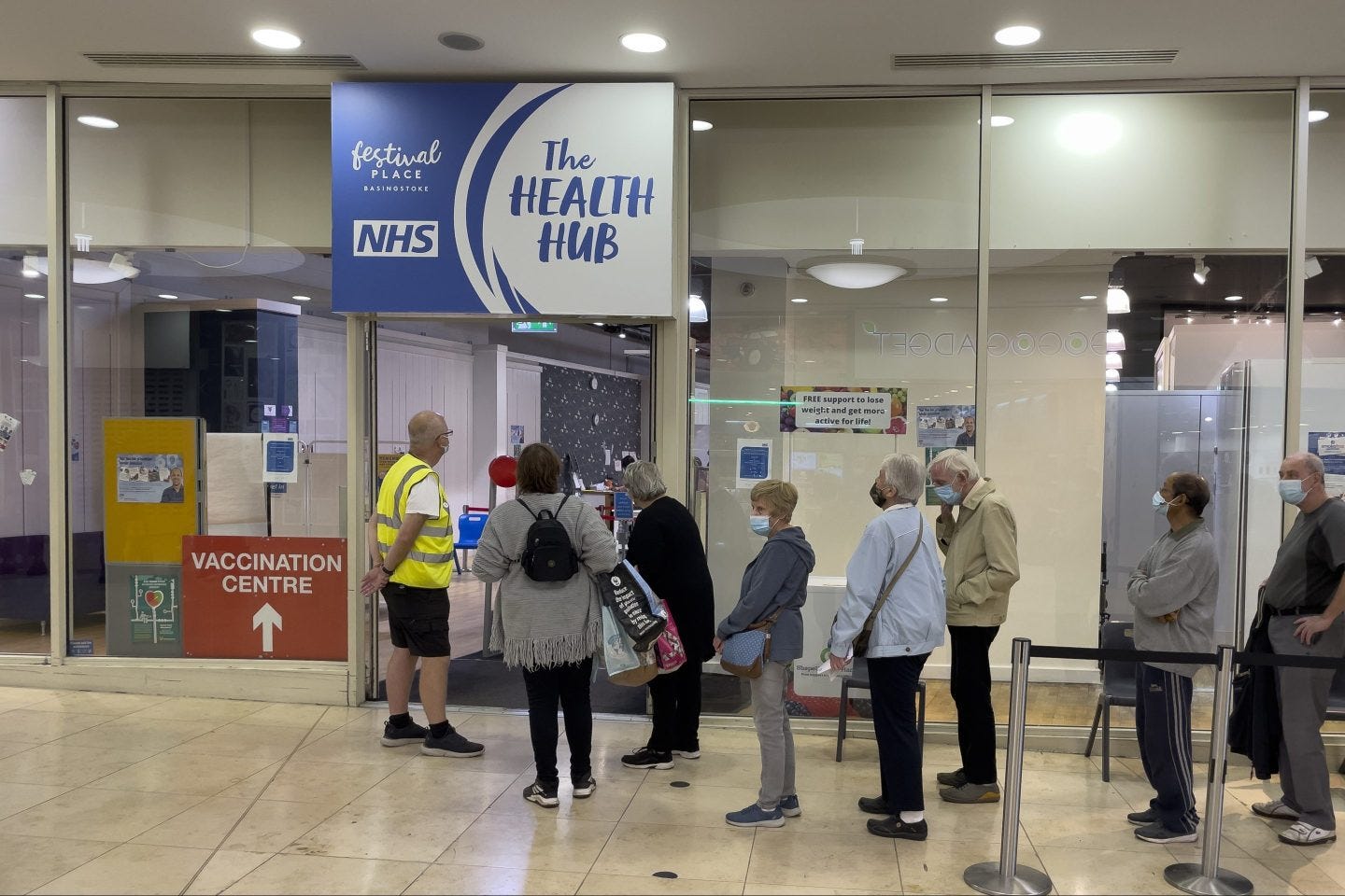 People waiting outside a clinic with masks on