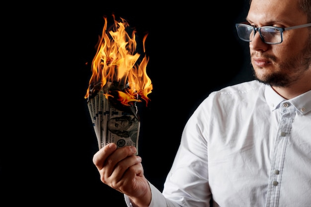 Premium Photo | A man holds burning money in his hand