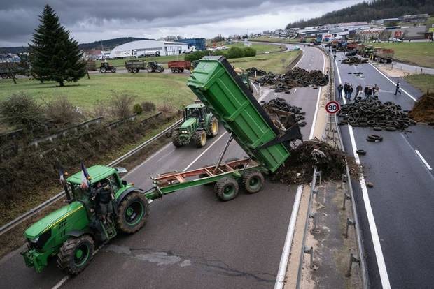 A truck dumping tires to block a roadway during the farmers protest in France