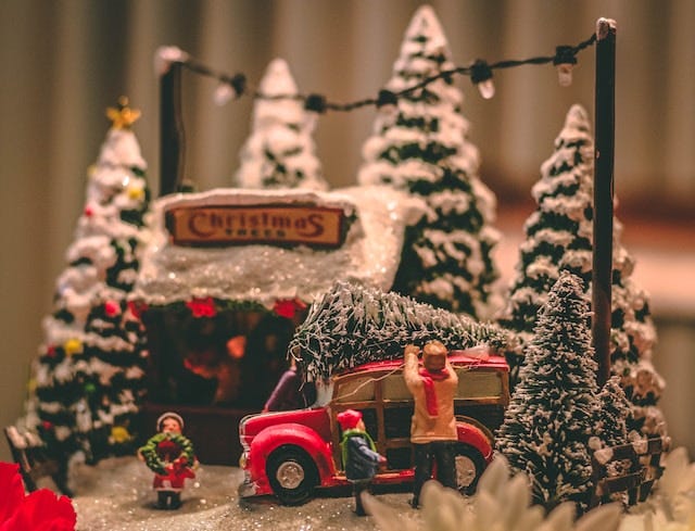 Nostalgic snow-scene of loading a Christmas tree onto the top of a car
