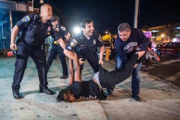 police smiling arresting protestor 2015