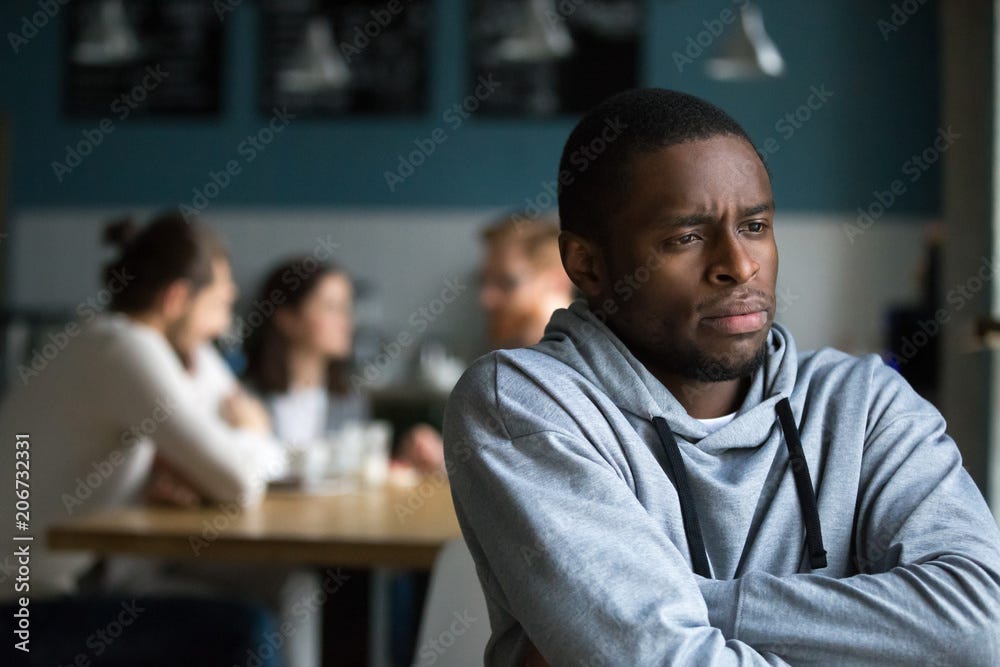 Frustrated excluded outstand african american man suffers from bullying or  racial discrimination having no friends sitting alone in cafe, sad  depressed black guy upset being rejected by white people Stock Photo |