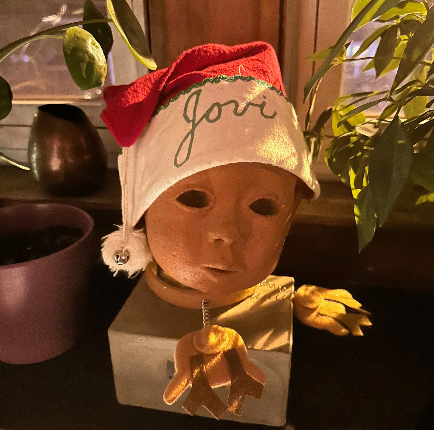 Jowi baby head clay bust with Santa hat saying "Jovi"