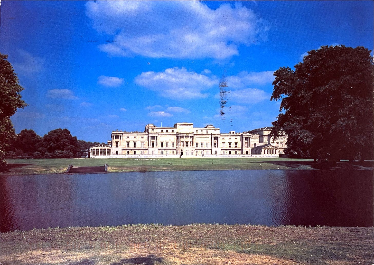 Photo of a large mansion or castle-like building overlooking a lake.