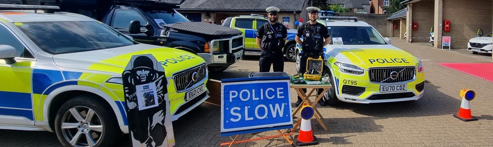 roads policing officers with cars, cones and other equipment.