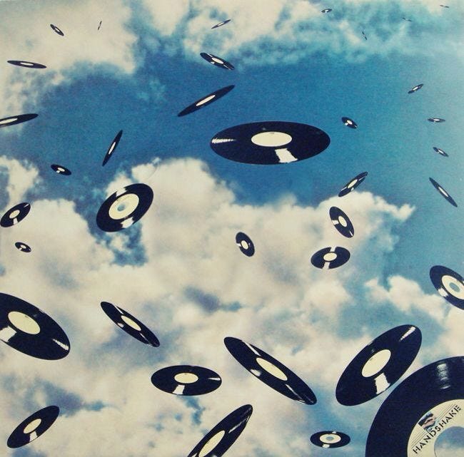 This may contain: the sky is filled with black and white circles flying in the air, all around an old record