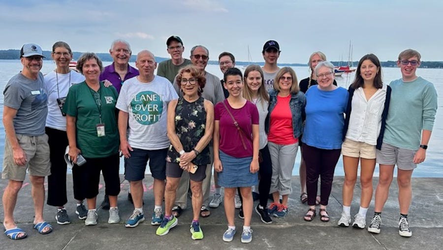 Photo of group of participants standing facing camera at lake shore.