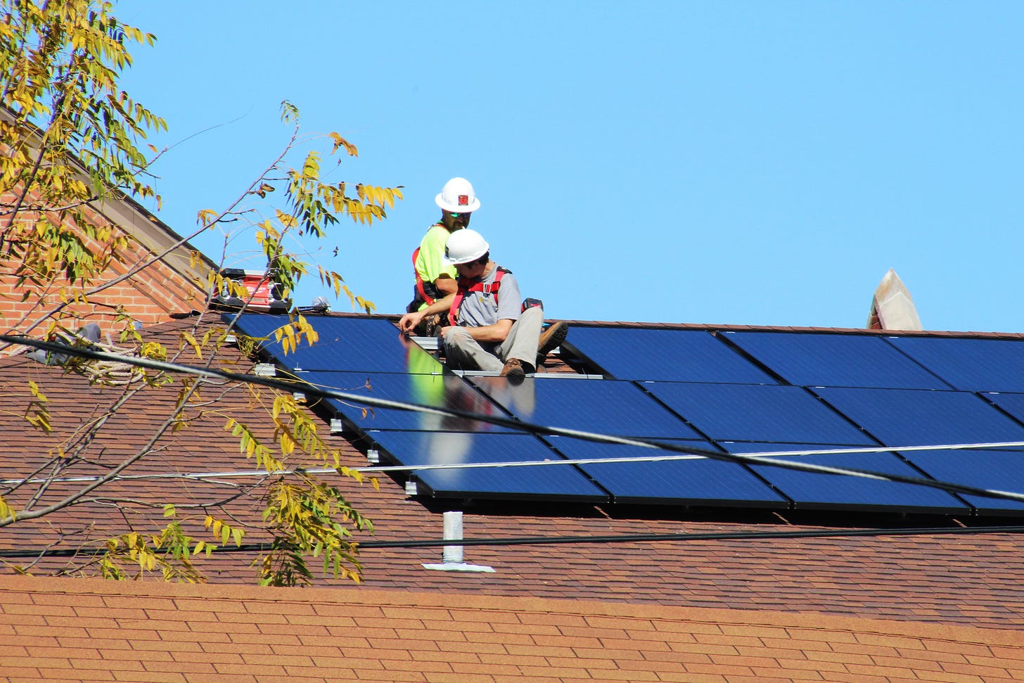 Photo of two workers installing solar panels on two sloping roofs at First Presbyterian Church in Jeffersonville, Indiana in 2015.