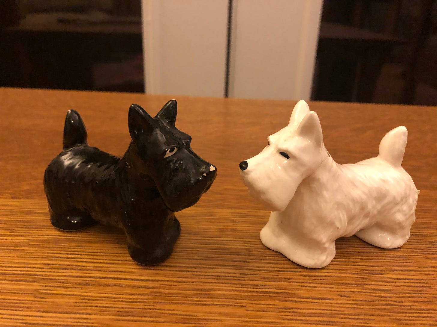 Salt and pepper shakers in the shape of a West Highland terrier and a Scottish terrier (white and black).