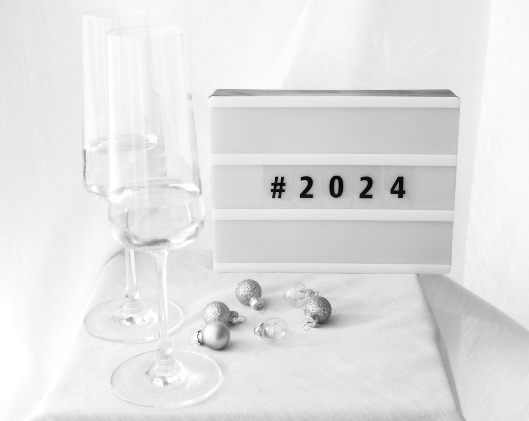 a table topped with two glasses of wine and a clock