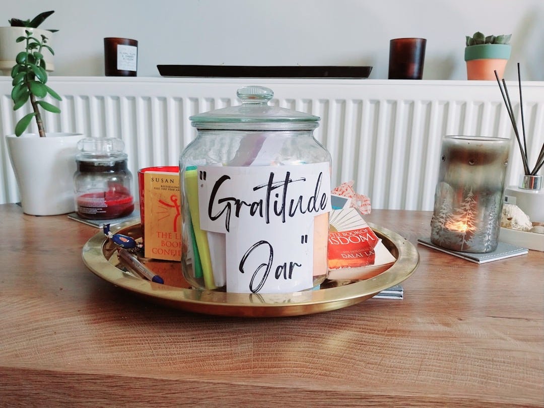 a jar filled with books on top of a wooden table