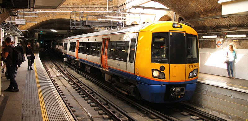 A London Overground train arriving at a station
