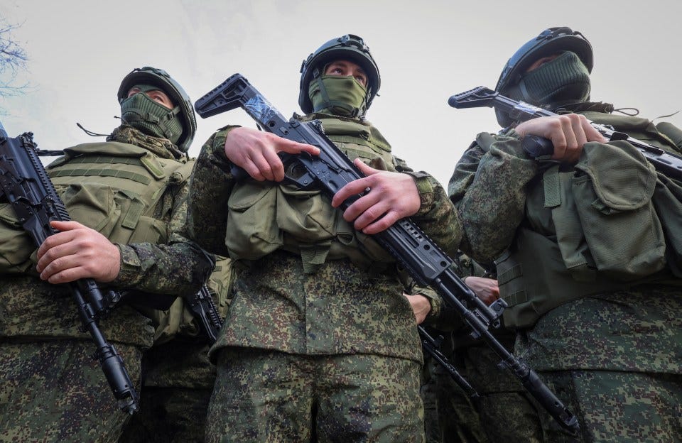 Soldiers in camouflage uniforms holding rifles.