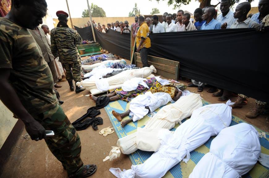 Intolerance aftermath: People stand near bodies found in a mosque and surrounding streets in Bangui, the capital of the Central African Republic, on Thursday after overnight violence.