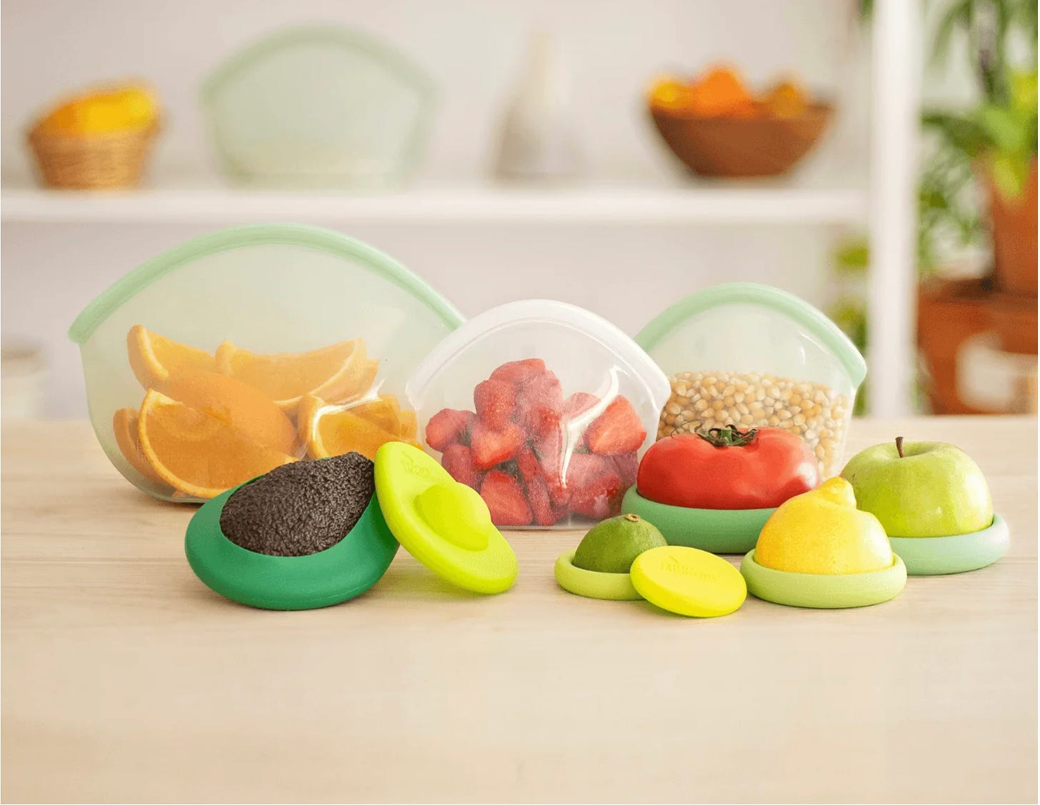 A photo of the "eco essentials" bundle, including silicon covers on a lemon, lime, apple, tomato, and avocado, and three resealable bags.
